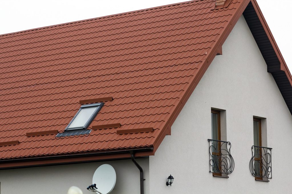 Toiture en tuiles rouges avec lucarne et antenne satellite.